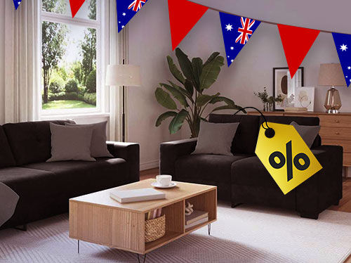 Living room scene with a dark sofa, armchair, and a coffee table, decorated with Australian flag bunting and a large yellow percentage discount tag. Click to see the products in the collection.