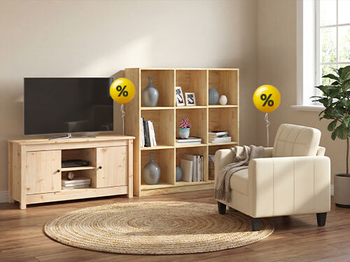A living room scene featuring a television, TV stand, bookshelf, armchair, and rug, with yellow balloons displaying percentage signs indicating a sale. Click to see the products in the collection.