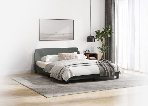 Bedroom interior featuring a bed with grey headboard, a large framed art print on the wall, and a potted plant.