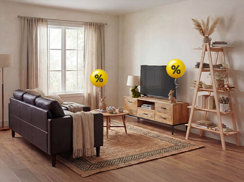 A modern living room setting showcases a brown leather sofa, wooden entertainment center with a television displaying a discount, and a ladder shelf. Easter-themed decorations are also present. Click to see the products in the collection.