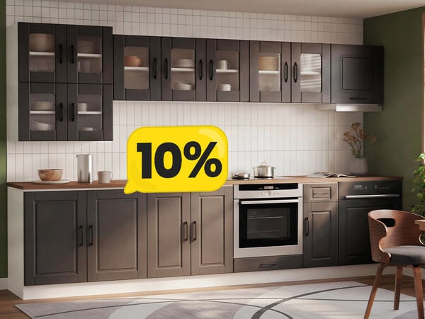 A kitchen interior featuring grey cabinets with glass-paneled doors, a white tile backsplash, and a stainless-steel oven. The scene is accented with a framed artwork and greenery, creating a modern and inviting feel. A yellow speech bubble overlay displays a 10% promotional offer. Click to see the products in the collection.