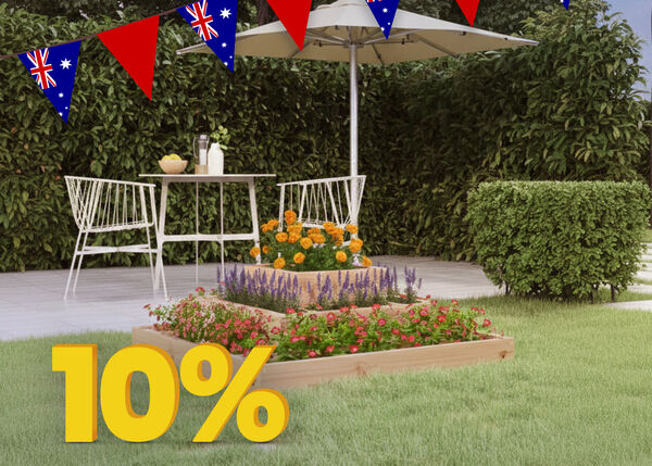Outdoor scene with a three-tiered wooden planter box filled with red, purple, and orange flowers, Australian flag bunting overhead, and a yellow percentage sign tag in the foreground.