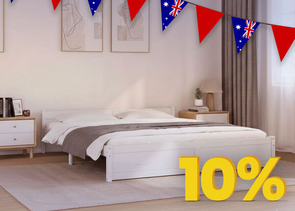Bedroom scene with a white bed and bedside table, decorated with Australian flag bunting and a yellow discount tag.
