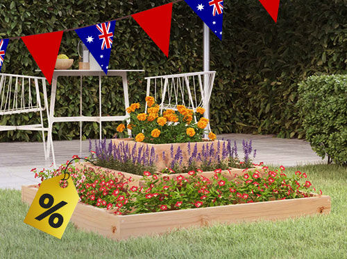 Outdoor scene with a three-tiered wooden planter box filled with red, purple, and orange flowers, Australian flag bunting overhead, and a yellow percentage sign tag in the foreground. Click to see the products in the collection.