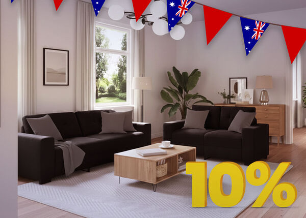 Living room scene with a dark sofa, armchair, and a coffee table, decorated with Australian flag bunting and a large yellow percentage discount tag.