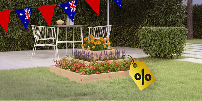 Outdoor scene with a three-tiered wooden planter box filled with red, purple, and orange flowers, Australian flag bunting overhead, and a yellow percentage sign tag in the foreground. Click to see the products in the collection.