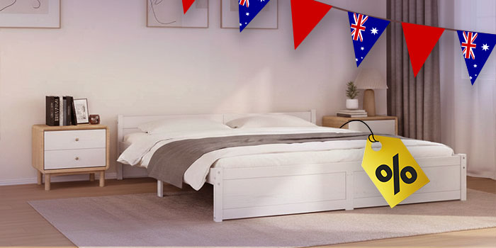 Bedroom scene with a white bed and bedside table, decorated with Australian flag bunting and a yellow discount tag. Click to see the products in the collection.