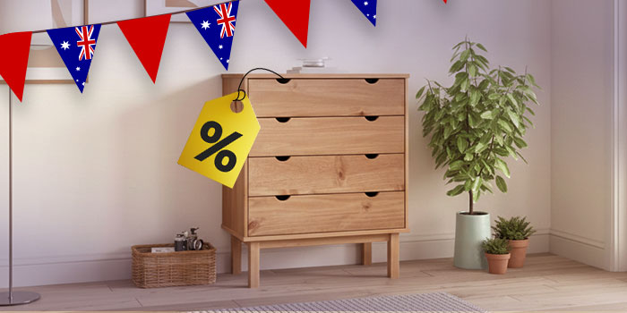 Wooden four-drawer dresser with a yellow percentage sign tag hanging from Australian flag bunting. Click to see the products in the collection.