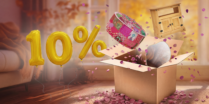 Open box with colourful pouffe, wooden TV cabinet, and mirror popping out, purple petals scattered around in an indoor setting. Yellow balloons show a 10% discount. Click to shop the collection.